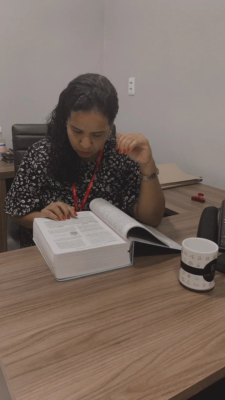 Pessoa estudando documento jurídico em uma mesa